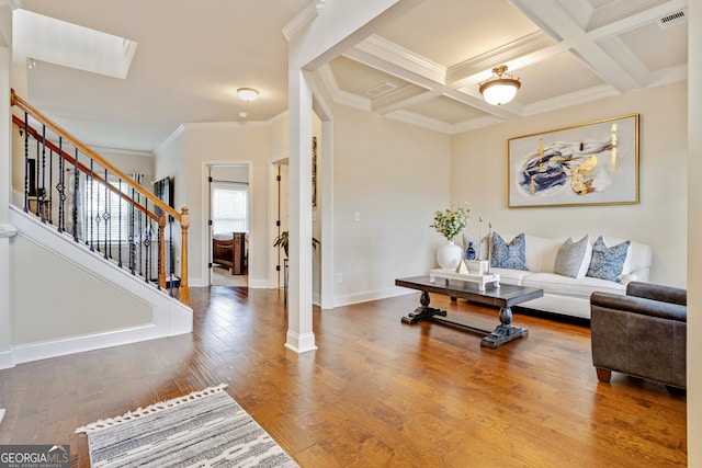 117 Elkins Blvd, Locust Grove, GA 30248 - living room featuring ornamental molding, stairs, beam ceiling, wood finished floors, and coffered ceiling