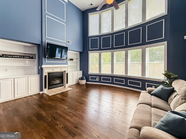 35 Paddle Boat Cv, Senoia, GA 30276 - living area featuring a high ceiling, ceiling fan, healthy amount of natural light, a fireplace with flush hearth, and built in features