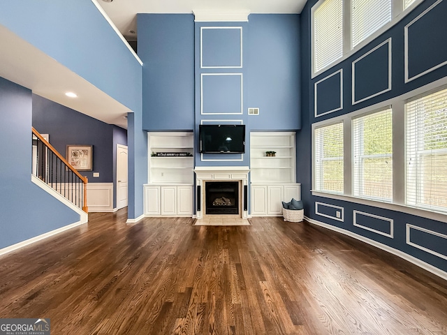 35 Paddle Boat Cv, Senoia, GA 30276 - unfurnished living room featuring a high ceiling, dark wood-style flooring, stairs, and a fireplace with flush hearth