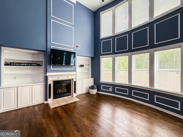 35 Paddle Boat Cv, Senoia, GA 30276 - unfurnished living room featuring dark wood finished floors, a fireplace with flush hearth, and a high ceiling