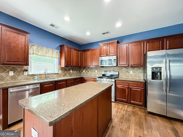 35 Paddle Boat Cv, Senoia, GA 30276 - kitchen with appliances with stainless steel finishes, light wood finished floors, a center island, tasteful backsplash, and recessed lighting