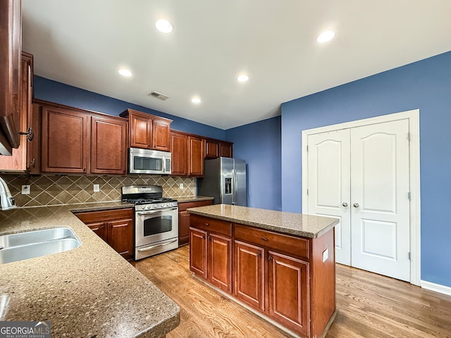 35 Paddle Boat Cv, Senoia, GA 30276 - kitchen with stainless steel appliances, light wood-style flooring, a center island, decorative backsplash, and recessed lighting
