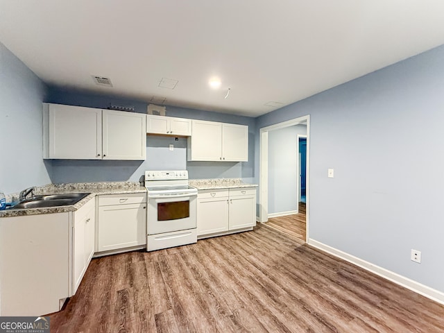 35 Paddle Boat Cv, Senoia, GA 30276 - kitchen featuring white electric range, wood finished floors, white cabinets, and light countertops