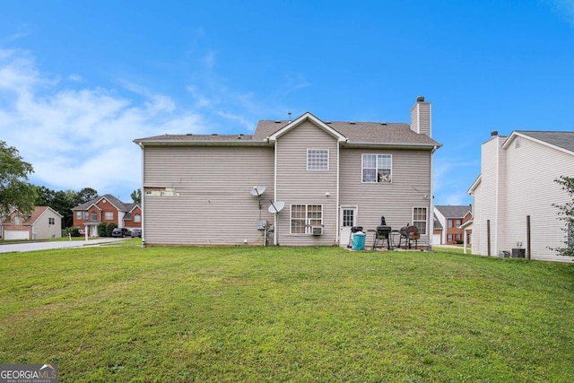 1135 Misty Meadows Way, Hampton, GA 30229 - rear view of property with a lawn, a chimney, and a patio area