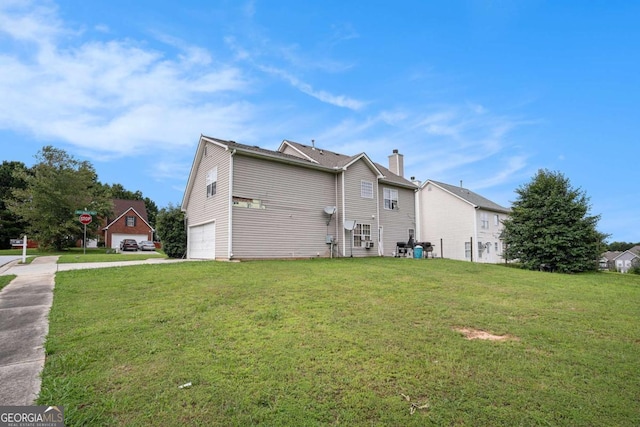 1135 Misty Meadows Way, Hampton, GA 30229 - rear view of property with an attached garage, concrete driveway, a lawn, and a chimney