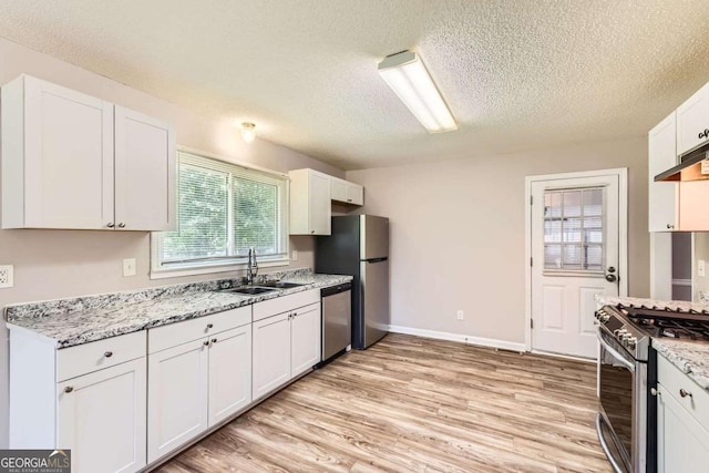 11473 Summer Creek Dr, Hampton, GA 30228 - kitchen with a textured ceiling, appliances with stainless steel finishes, light wood-style floors, and white cabinetry