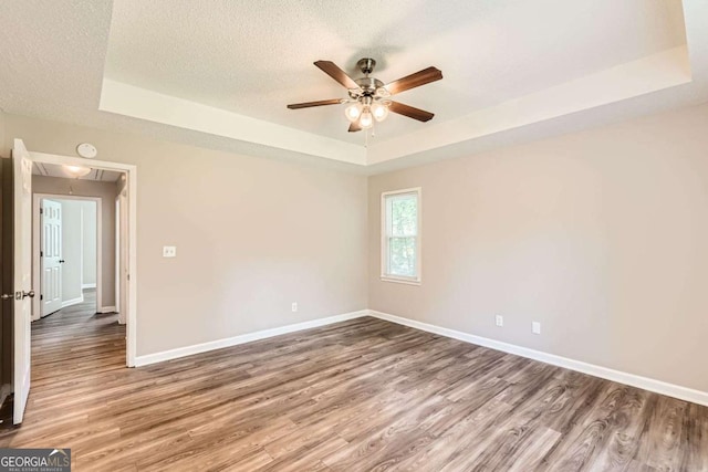 11473 Summer Creek Dr, Hampton, GA 30228 - spare room with a tray ceiling, attic access, a ceiling fan, wood finished floors, and a textured ceiling