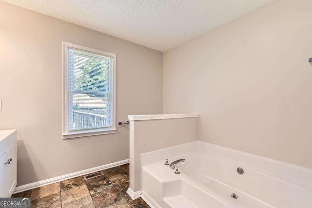11473 Summer Creek Dr, Hampton, GA 30228 - full bath featuring a bath, vanity, a textured ceiling, and stone finish floors