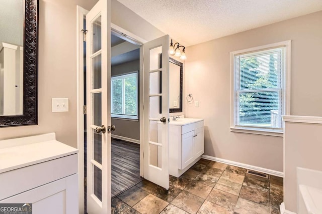 11473 Summer Creek Dr, Hampton, GA 30228 - full bath featuring french doors, vanity, stone finish floors, and a textured ceiling