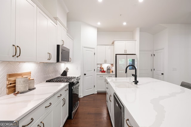 203 Holden Way, Woodstock, GA 30189 - kitchen featuring stainless steel appliances, dark wood-style flooring, tasteful backsplash, recessed lighting, and a center island with sink