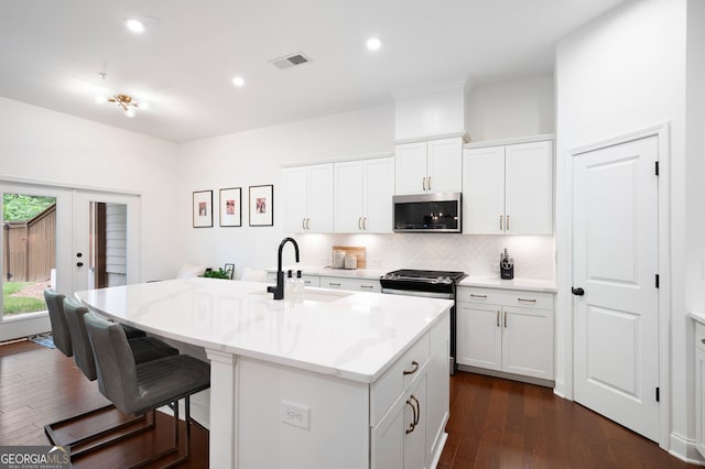 203 Holden Way, Woodstock, GA 30189 - kitchen featuring appliances with stainless steel finishes, tasteful backsplash, a breakfast bar, french doors, and a kitchen island with sink