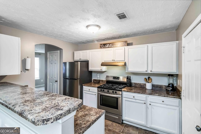 1147 Dunivin Dr, Jonesboro, GA 30238 - kitchen featuring stainless steel appliances, under cabinet range hood, white cabinets, and a textured ceiling