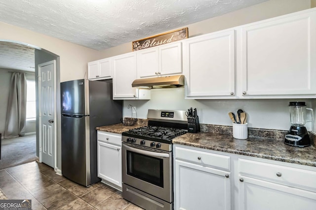 1147 Dunivin Dr, Jonesboro, GA 30238 - kitchen with appliances with stainless steel finishes, under cabinet range hood, arched walkways, white cabinetry, and a textured ceiling