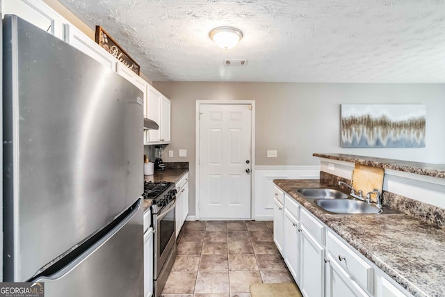 1147 Dunivin Dr, Jonesboro, GA 30238 - kitchen with stainless steel appliances, white cabinets, a textured ceiling, and exhaust hood