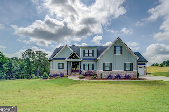 3076 E Lake Rd, Mcdonough, GA 30252 - view of front of home with board and batten siding, a front yard, stone siding, driveway, and an attached garage