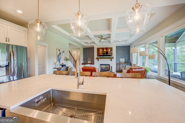 3076 E Lake Rd, Mcdonough, GA 30252 - kitchen featuring stainless steel fridge with ice dispenser, a large fireplace, coffered ceiling, hanging light fixtures, and light countertops