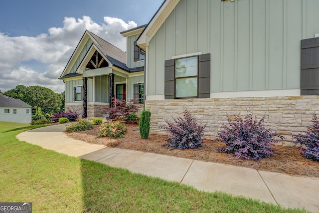 3076 E Lake Rd, Mcdonough, GA 30252 - craftsman house with board and batten siding, stone siding, a front lawn, and a shingled roof