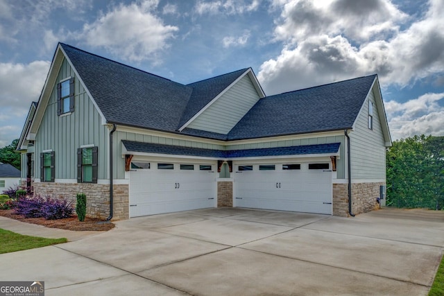 3076 E Lake Rd, Mcdonough, GA 30252 - view of front of home with board and batten siding, stone siding, a shingled roof, a garage, and concrete driveway