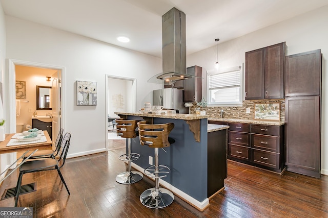 496 Rankin St NE, Atlanta, GA 30308 - kitchen featuring freestanding refrigerator, a kitchen breakfast bar, dark wood-type flooring, dark brown cabinetry, and recessed lighting
