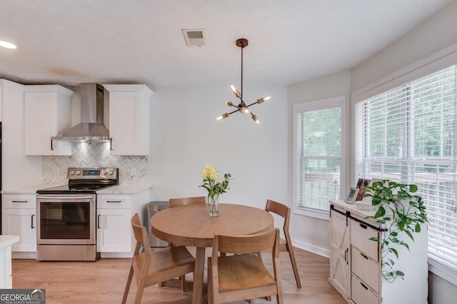 1406 Marshview Ct, Hoschton, GA 30548 - kitchen with stainless steel range with electric stovetop, wall chimney exhaust hood, light wood finished floors, and tasteful backsplash