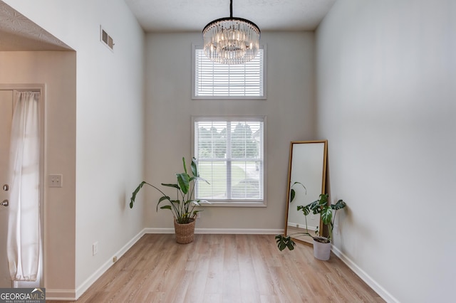 1406 Marshview Ct, Hoschton, GA 30548 - foyer featuring wood finished floors, plenty of natural light, and a chandelier