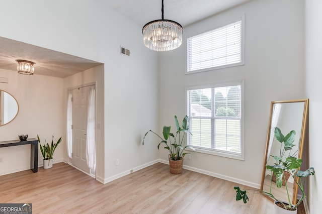 1406 Marshview Ct, Hoschton, GA 30548 - foyer entrance featuring a towering ceiling, wood finished floors, and a chandelier