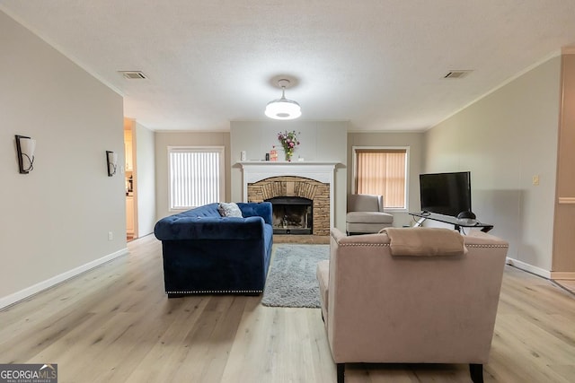 1185 Mp Martin Rd, Brooklet, GA 30415 - living area featuring light wood-type flooring, crown molding, healthy amount of natural light, and a fireplace
