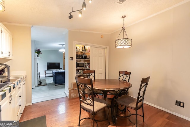 1185 Mp Martin Rd, Brooklet, GA 30415 - dining room with wood finished floors, crown molding, and a textured ceiling