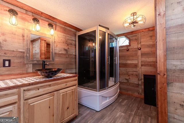 1185 Mp Martin Rd, Brooklet, GA 30415 - bathroom with wooden walls, vanity, wood finished floors, a textured ceiling, and a tub to relax in