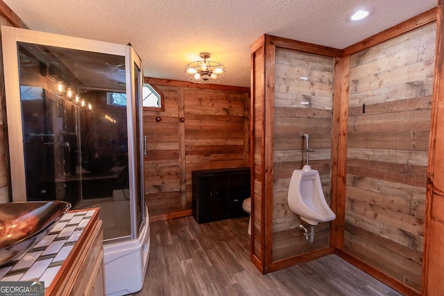 1185 Mp Martin Rd, Brooklet, GA 30415 - full bathroom with wooden walls, wood finished floors, a stall shower, a textured ceiling, and a chandelier