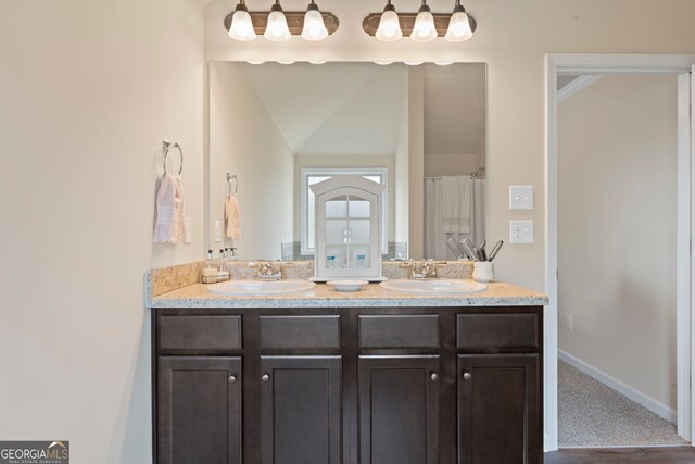 1001 Hartwell Rd, Locust Grove, GA 30248 - bathroom featuring double vanity and vaulted ceiling