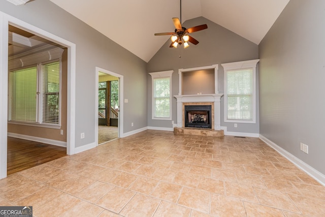 303 Sage Meadows Ln, Bonaire, GA 31005 - unfurnished living room with vaulted ceiling, ceiling fan, a tiled fireplace, and tile patterned flooring