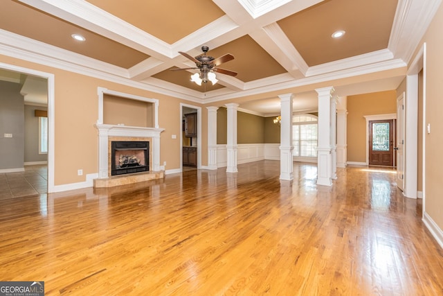 303 Sage Meadows Ln, Bonaire, GA 31005 - unfurnished living room featuring ornate columns, ornamental molding, a fireplace with raised hearth, beam ceiling, and ceiling fan