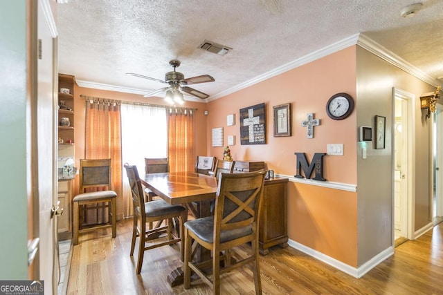 4782 Two Oak Dr, Macon, GA 31210 - dining space with a textured ceiling, wood finished floors, a ceiling fan, and crown molding
