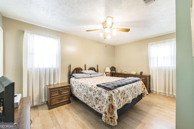 4782 Two Oak Dr, Macon, GA 31210 - bedroom with multiple windows, light wood finished floors, a textured ceiling, and ceiling fan
