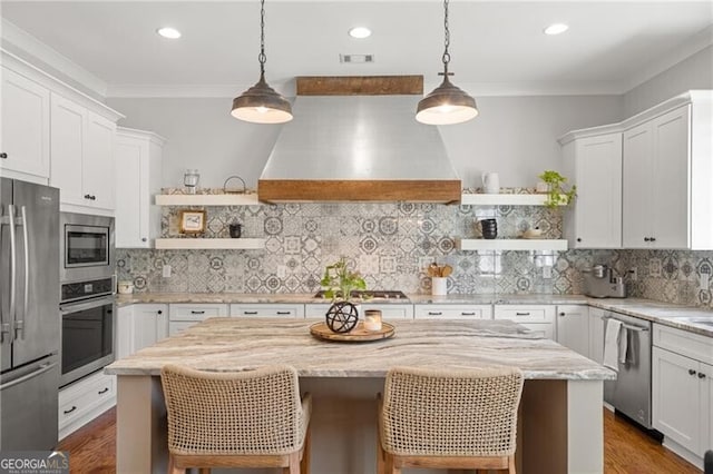 200 Ivy Meadow Way, Ball Ground, GA 30107 - kitchen with open shelves, stainless steel appliances, wall chimney range hood, a kitchen island, and crown molding