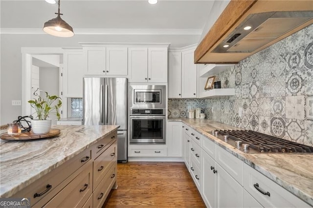 200 Ivy Meadow Way, Ball Ground, GA 30107 - kitchen featuring appliances with stainless steel finishes, wall chimney exhaust hood, crown molding, white cabinetry, and decorative light fixtures