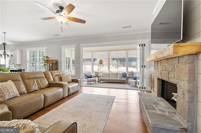 200 Ivy Meadow Way, Ball Ground, GA 30107 - living area with crown molding, a ceiling fan, a fireplace, wood finished floors, and a chandelier