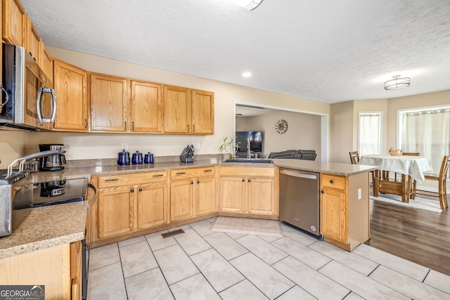 107 Line Creek Rd, Nicholson, GA 30565 - kitchen featuring appliances with stainless steel finishes, a peninsula, a textured ceiling, light tile patterned flooring, and recessed lighting
