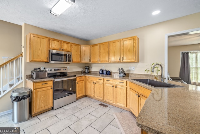 107 Line Creek Rd, Nicholson, GA 30565 - kitchen featuring appliances with stainless steel finishes, light tile patterned floors, a peninsula, a textured ceiling, and recessed lighting