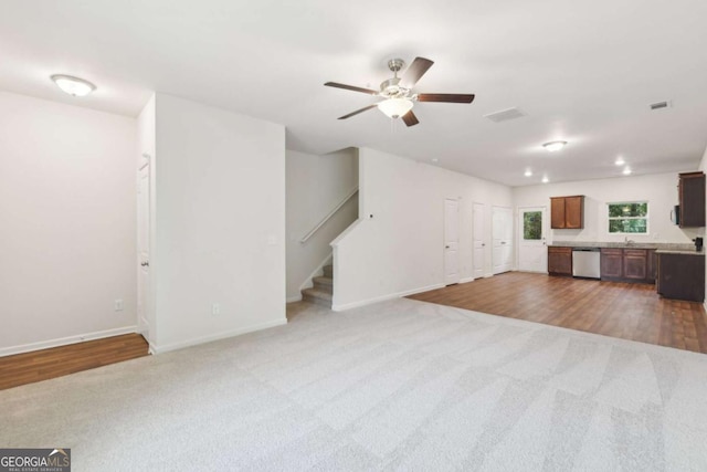 4001 Avalon Rd SW, Atlanta, GA 30331 - unfurnished living room with stairway, a ceiling fan, carpet floors, and wood finished floors