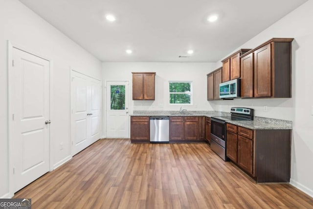 4001 Avalon Rd SW, Atlanta, GA 30331 - kitchen featuring appliances with stainless steel finishes, light wood finished floors, light stone counters, and recessed lighting