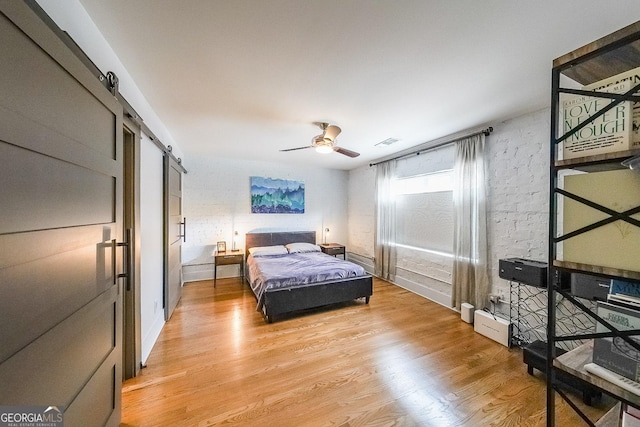1026 Saint Charles Ave NE Unit 15, Atlanta, GA 30306 - bedroom featuring a barn door, light wood-type flooring, and ceiling fan