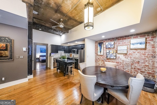 1026 Saint Charles Ave NE Unit 15, Atlanta, GA 30306 - dining room featuring a high ceiling, brick wall, light wood-style floors, ceiling fan, and wooden ceiling