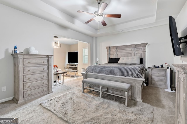 140 Canyons Ct, Hampton, GA 30228 - bedroom featuring light colored carpet, a tray ceiling, and ceiling fan