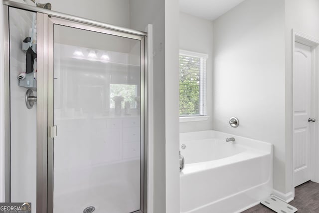 140 Canyons Ct, Hampton, GA 30228 - full bath featuring a garden tub, a stall shower, and wood finished floors