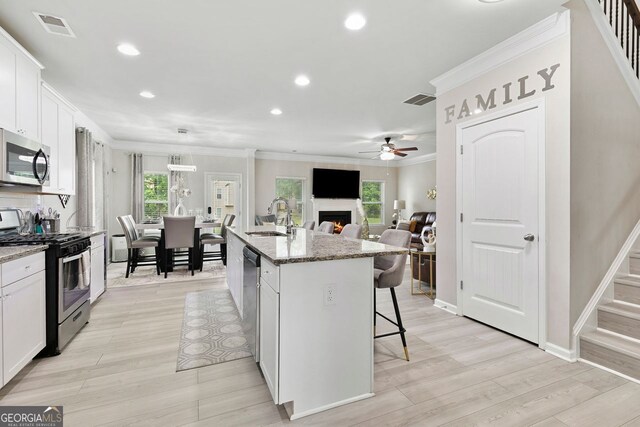 140 Canyons Ct, Hampton, GA 30228 - kitchen with stainless steel appliances, ceiling fan, ornamental molding, a breakfast bar, and recessed lighting