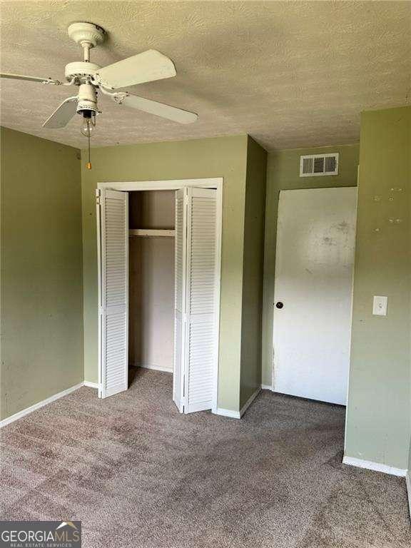 1807 Ashborough Cir SE Unit B, Marietta, GA 30067 - unfurnished bedroom with carpet floors, a closet, ceiling fan, and a textured ceiling