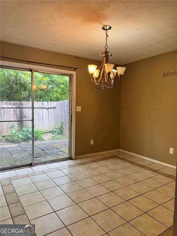 1807 Ashborough Cir SE Unit B, Marietta, GA 30067 - unfurnished room featuring a chandelier, a textured ceiling, and light tile patterned floors