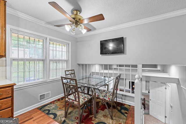 564 Allana Ct, Stone Mountain, GA 30087 - dining space with ornamental molding, ceiling fan, wood finished floors, and a textured ceiling